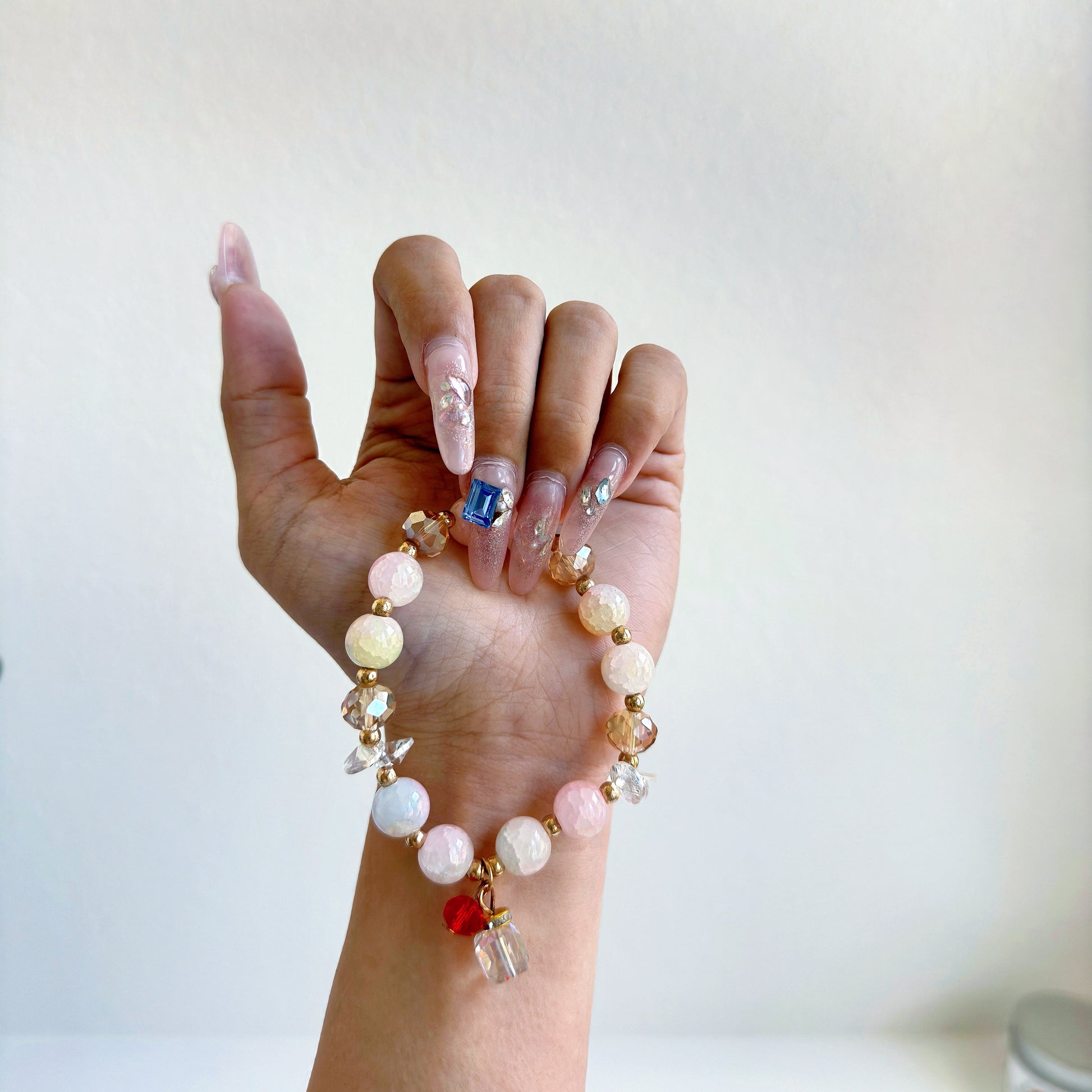 A simple, cute bracelet, with pink and bronze beads and an abstract present charm