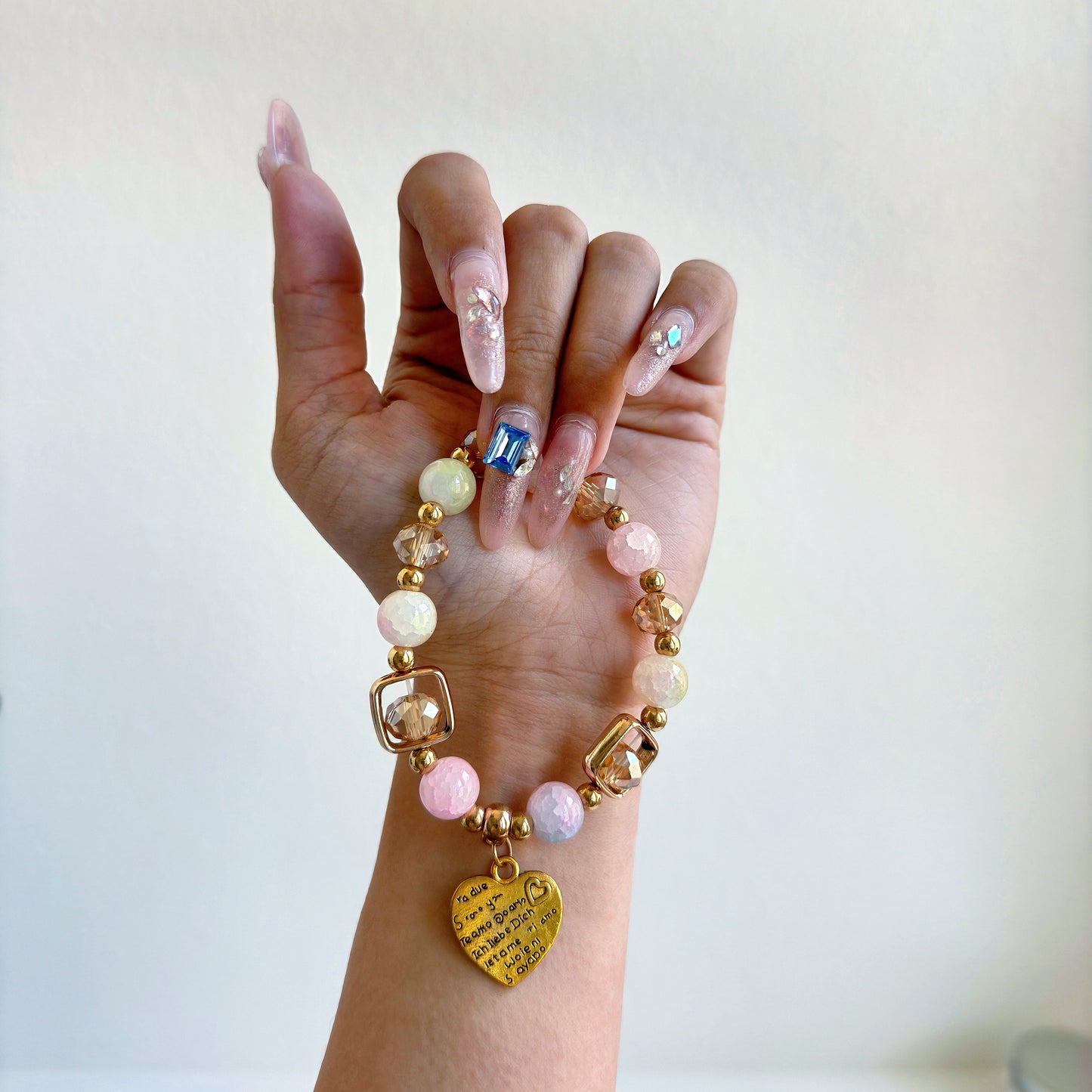 A glass beaded bracelet with bronze accents, with a charm that reads "I love you" in different languages, perfect for a gift for a woman in your life.