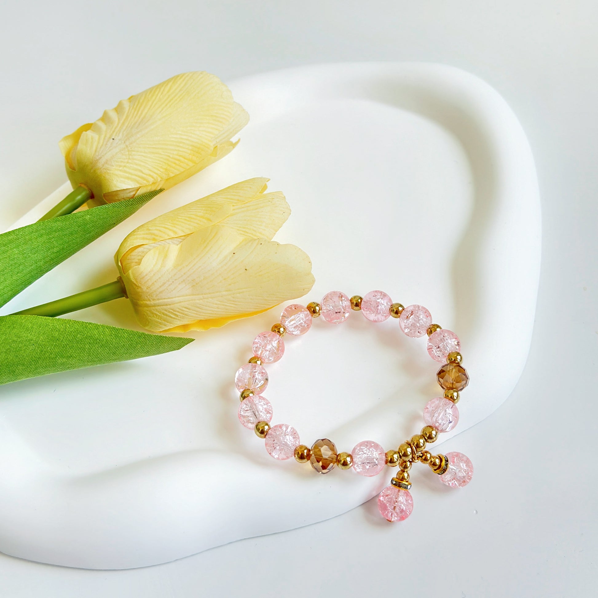 A bring pink bracelet with bronze accents, a cute jewelry piece ready to be worn.