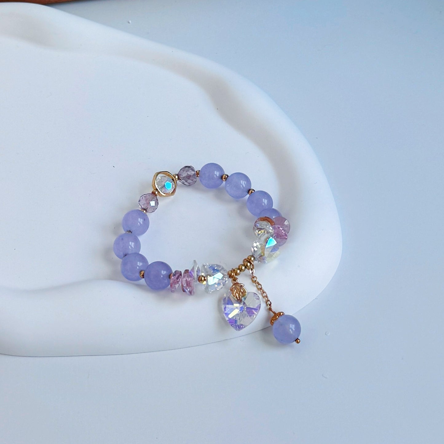 Light purple amethyst beaded bracelet with several crystal charms, including one in the shape of a heart.