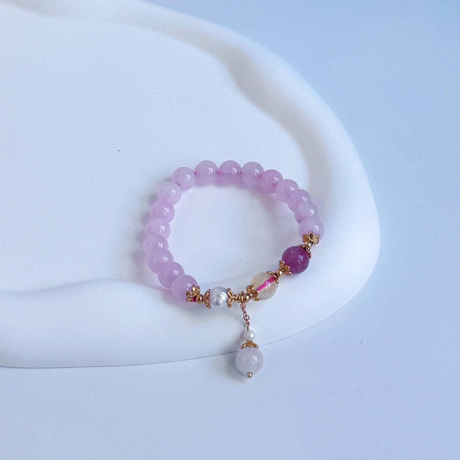 Light purple strawberry quartz bracelet with a pearl, a citrine bead, and a darker strawberry quartz bead.