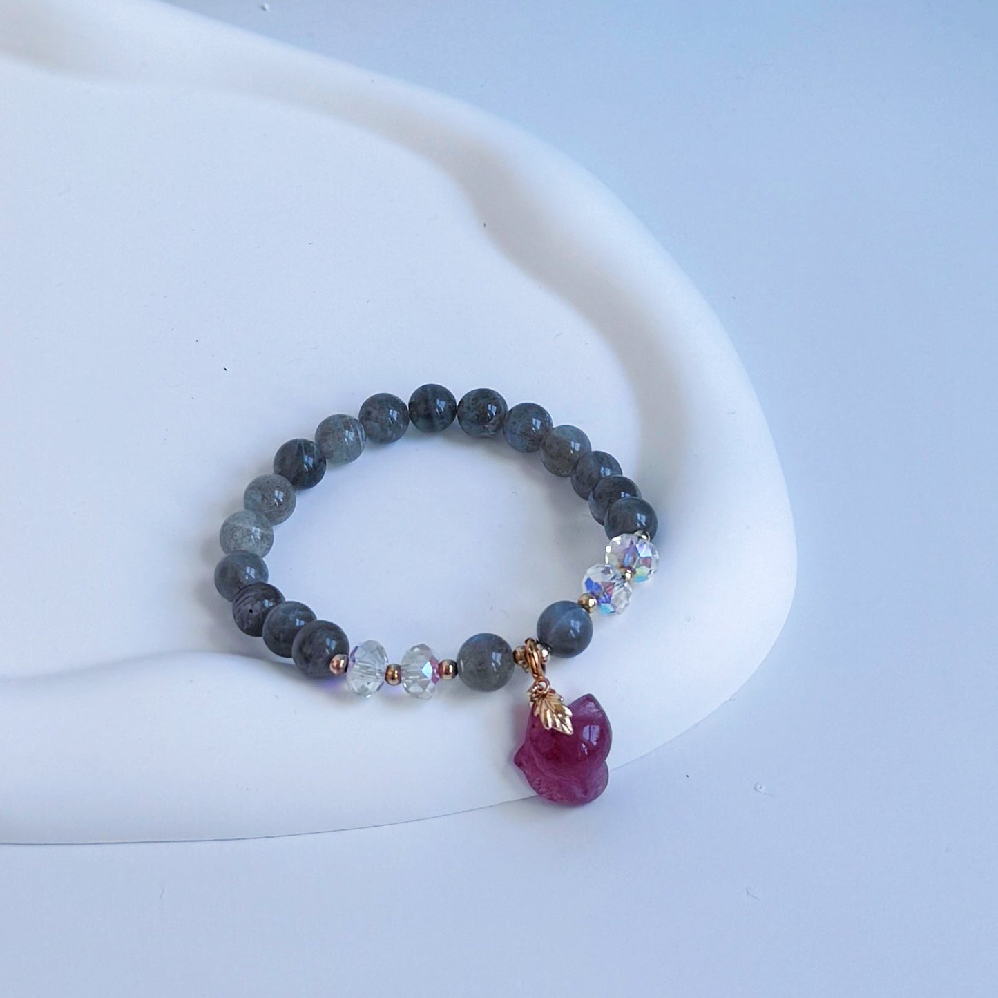 Moonstone beaded bracelet with a strawberry quartz charm in the shape of a fox.