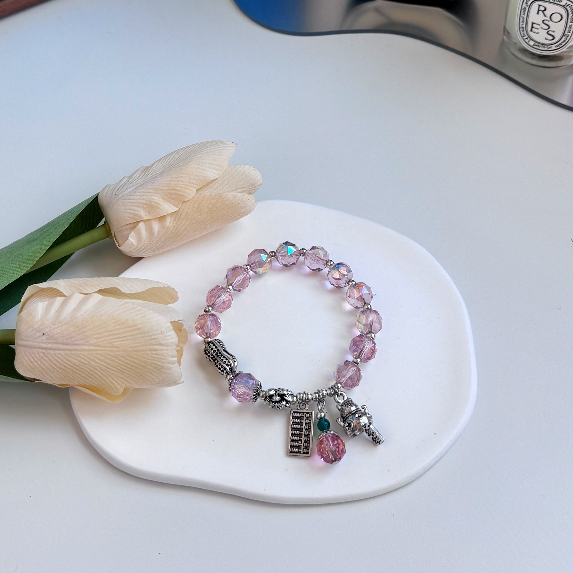 A cute bracelet with rose quartz beads and lucky charms, ideal as a gift for girlfriend, gift for sister, gift for daughter, gift for wife, or gift for friend.