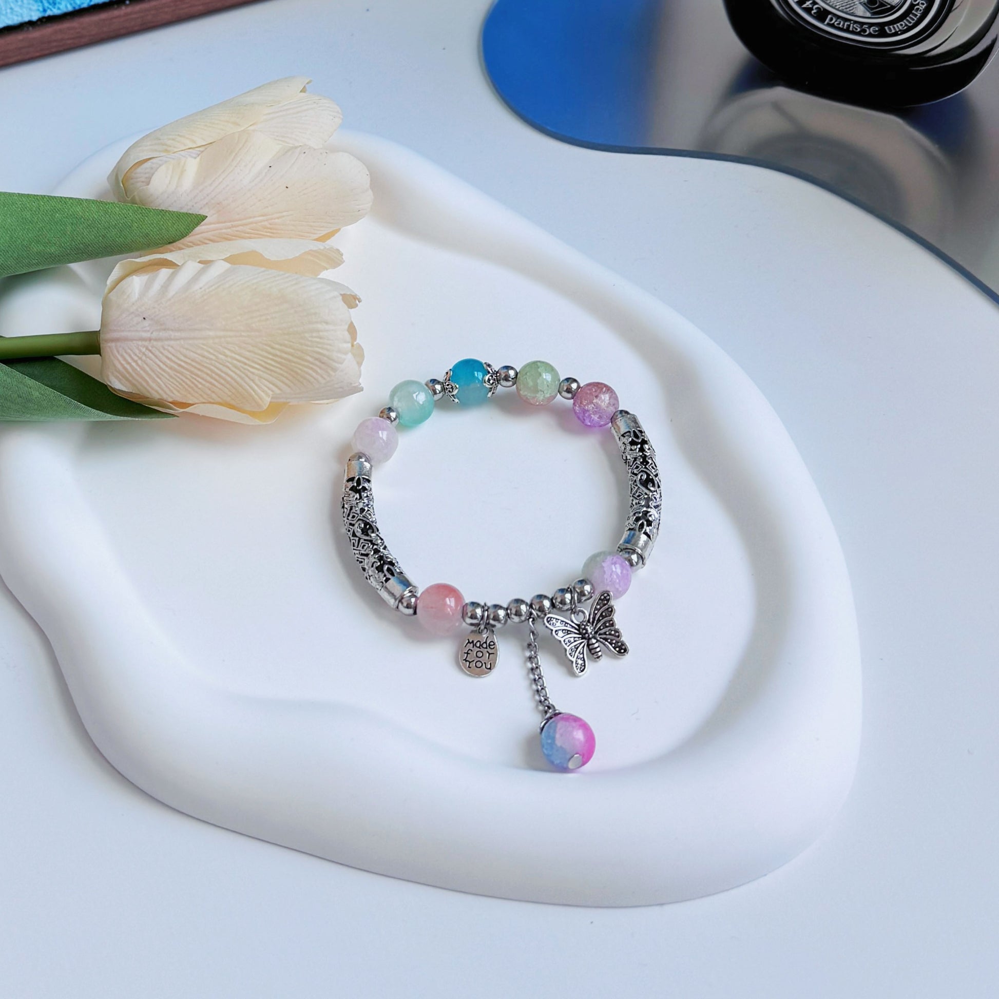 A multi-colored bracelet, sitting on a glass mirror, a perfect gift for friend, gift for girlfriend, gift for sister, gift for daughter, or gift for mom.