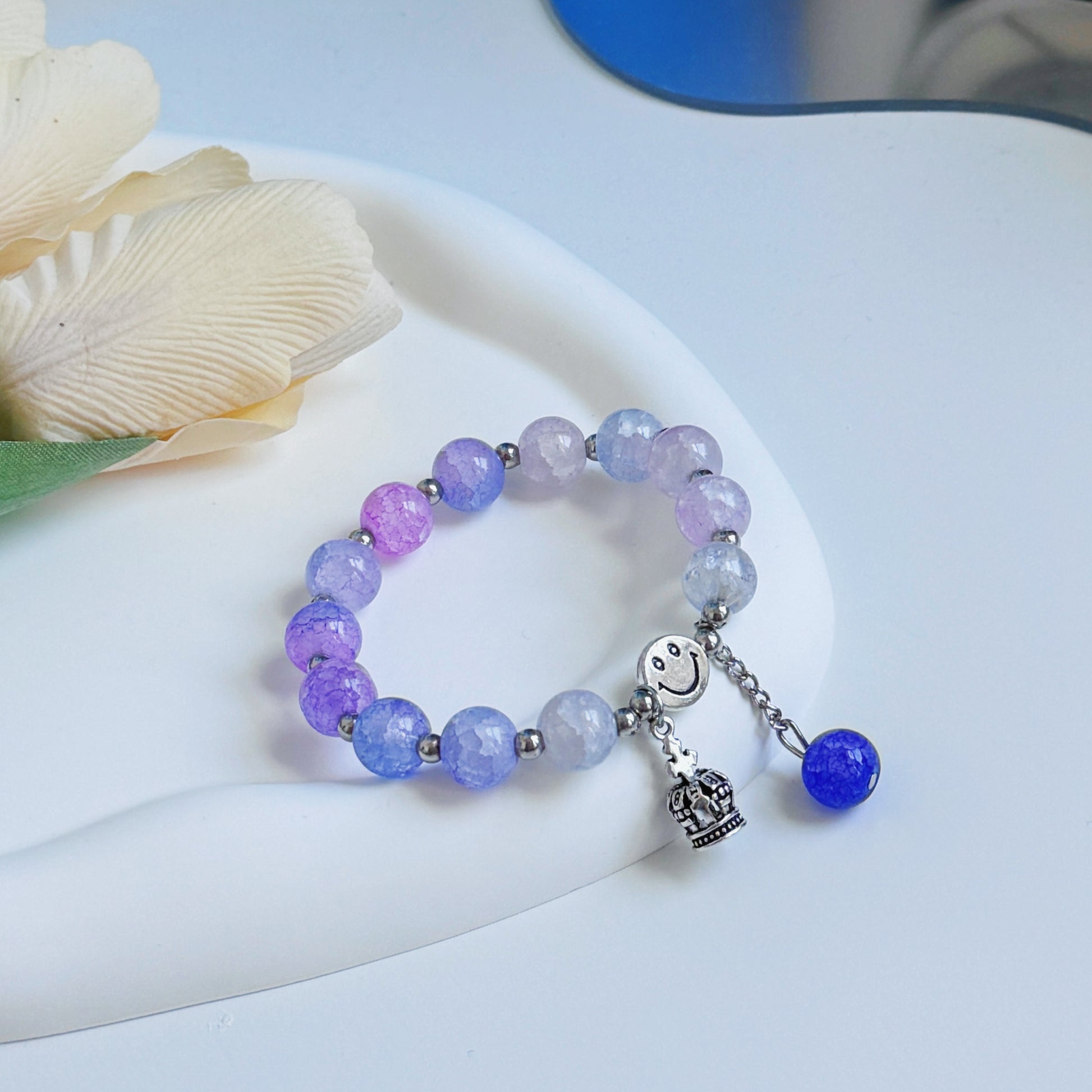 A cute, simple, and pretty purple bracelet with glass beads and a metal crown charm.