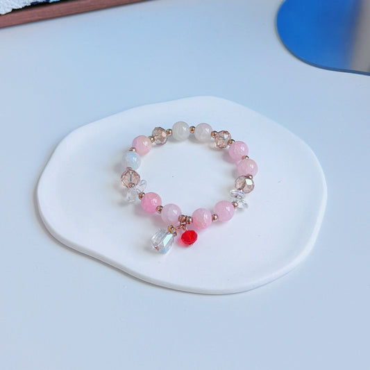 A simple, cute bracelet, with pink and gold beads and a small glass present charm