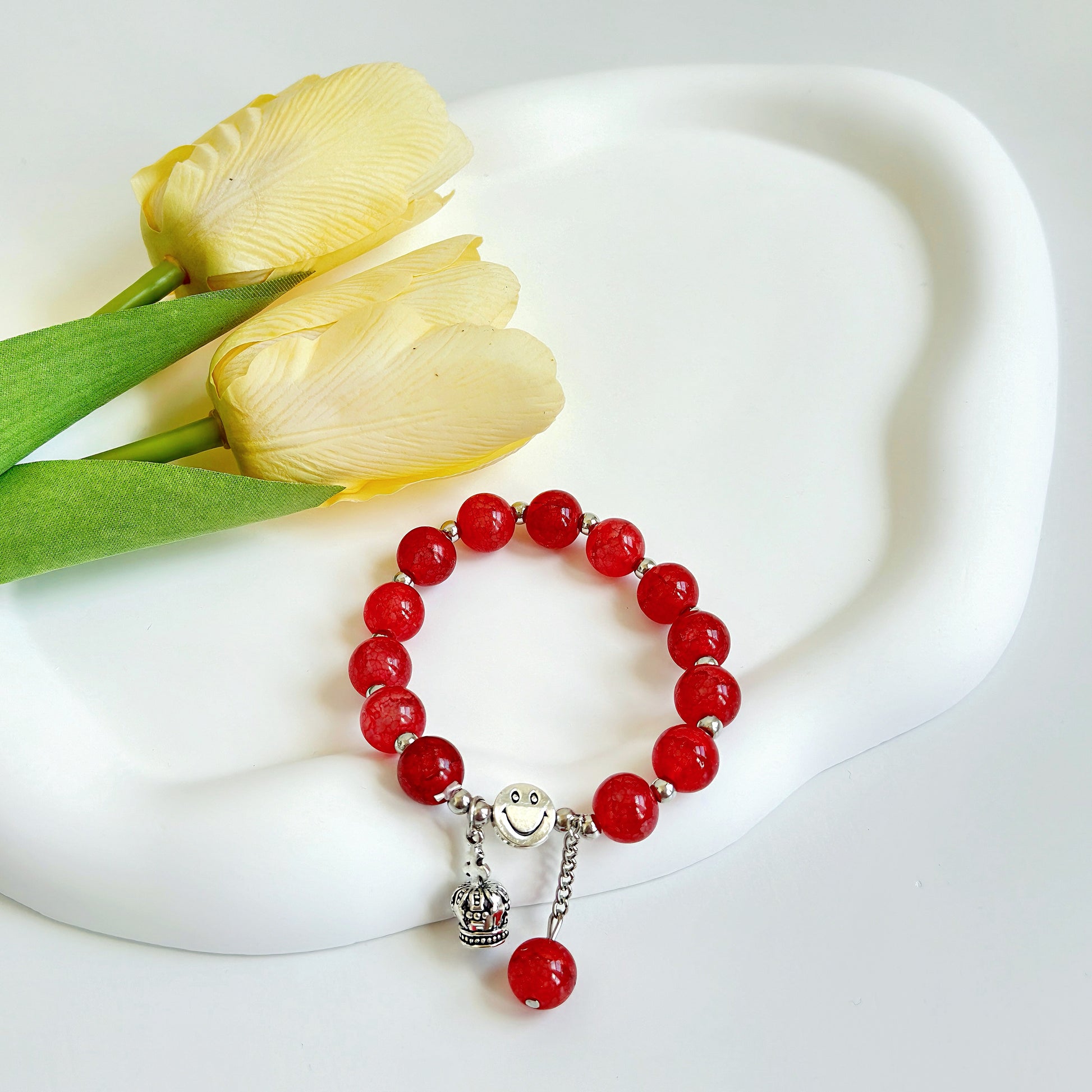 A bright red bracelet with metal accents, a great choice for anyone looking for a simple style.