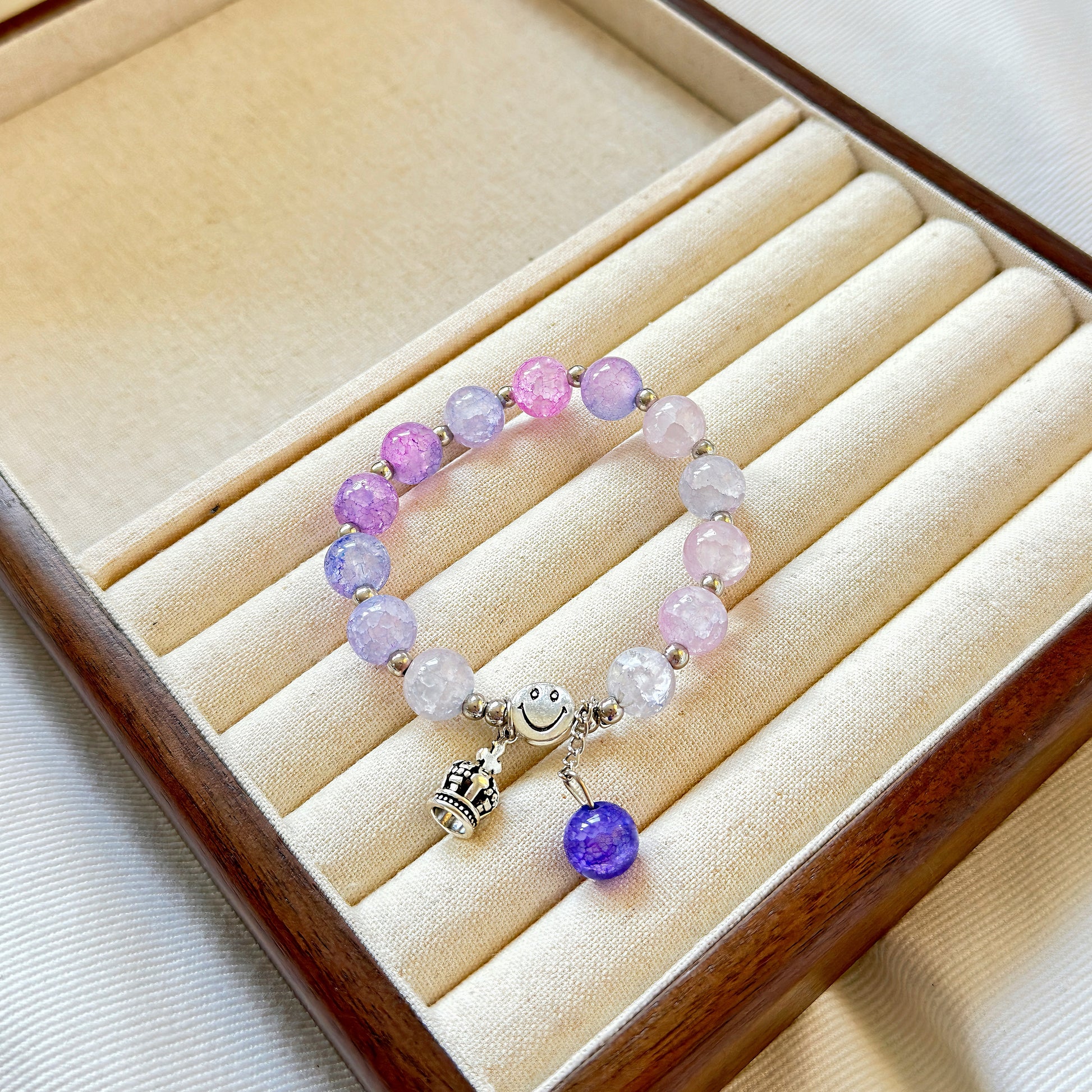 A beatiful and simple purple bracelet sitting in a warm jewelry box.