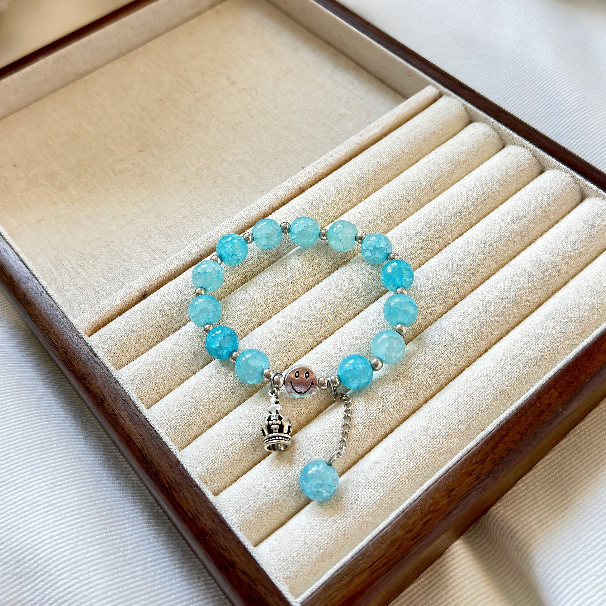 A light blue glass bead bracelet sitting in a warm jewelry tray, ready to be worn by a fashionable and stylish young woman or teen girl.