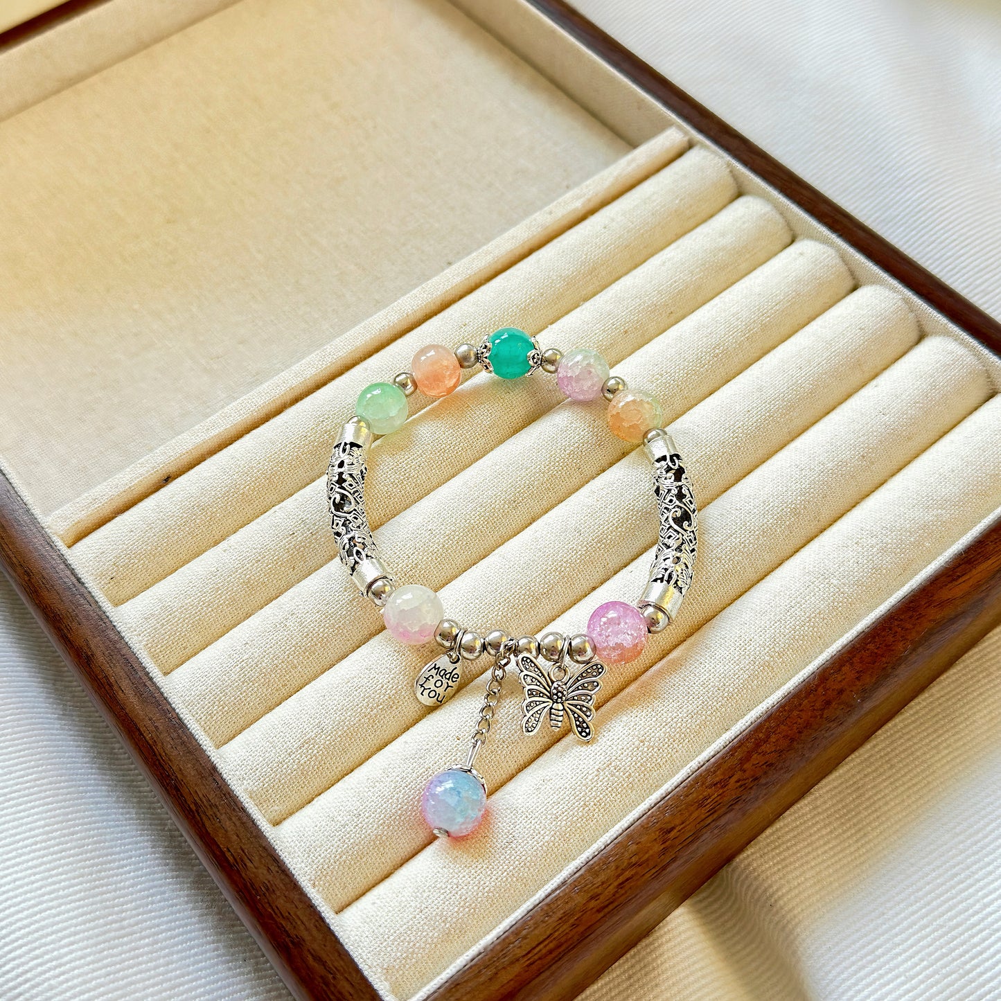 A pretty and sophisticated glass bead bracelet sitting in a warm jewelry box, ready to be worn by a fashionable young woman or stylish teen girl.